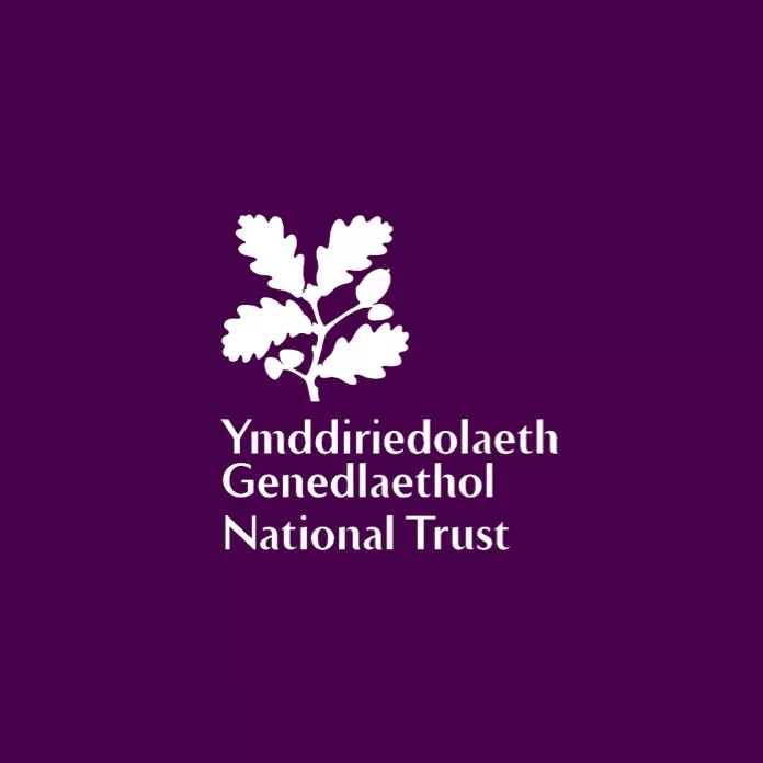 Logo of the National Trust with the Welsh text 'Ymddiriedolaeth Genedlaethol' against a purple background.